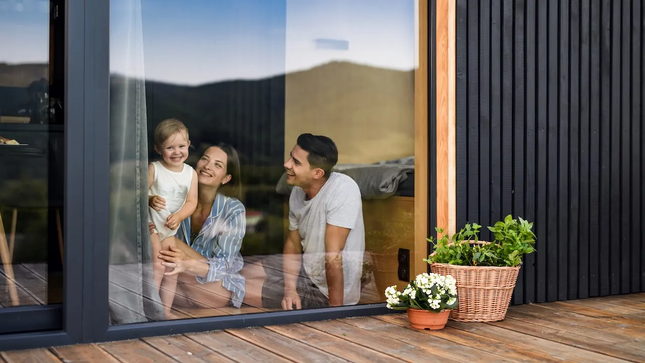 Young family looks out windows.