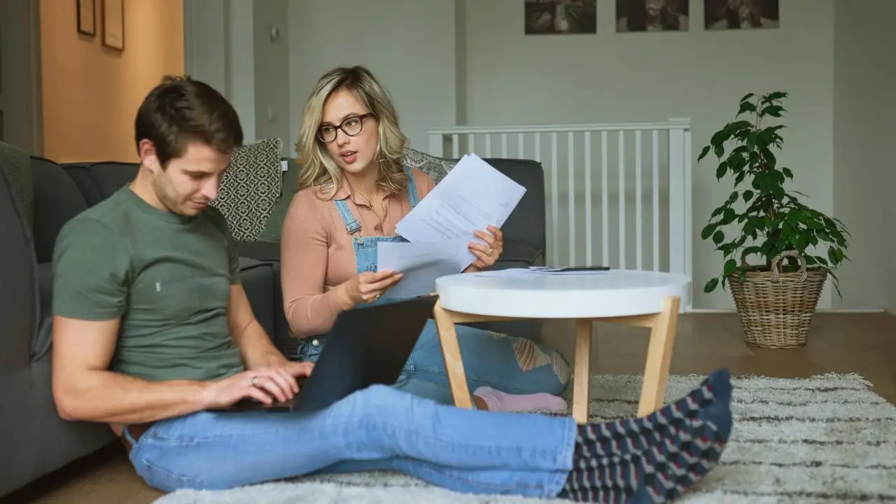 Young couple using a laptop while researching debt resolution programs