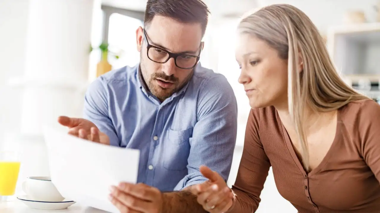 Young couple going through their financial bills at home.