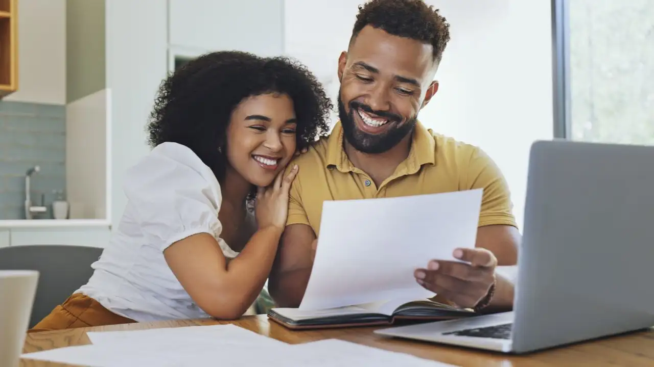 Happy young couple reviewing credit score before applying for personal loan