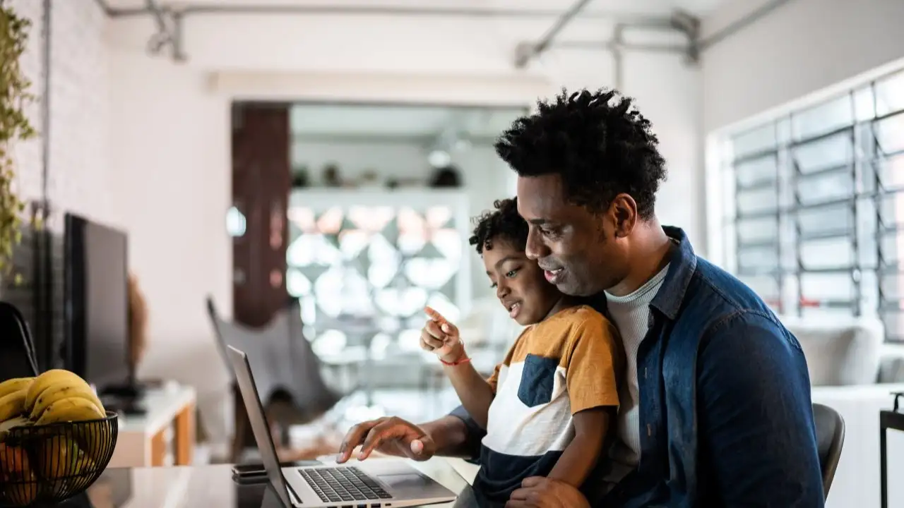 Father using the laptop with son at home