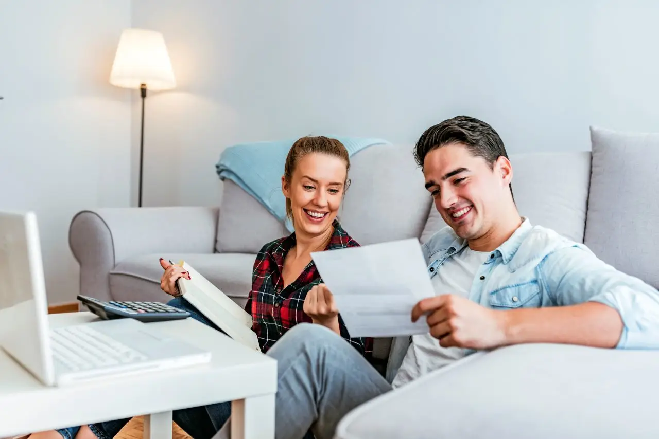 Happy couple doing finances at home.