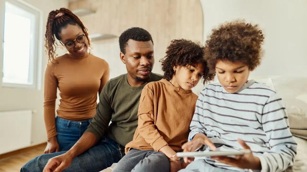 Young parents and their kids using digital tablet after moving into a new home.