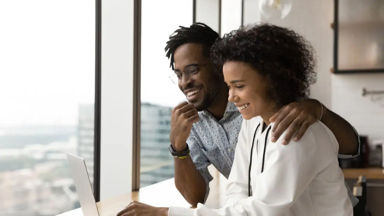 Happy couple looking at web and looking for information about the principle of a loan