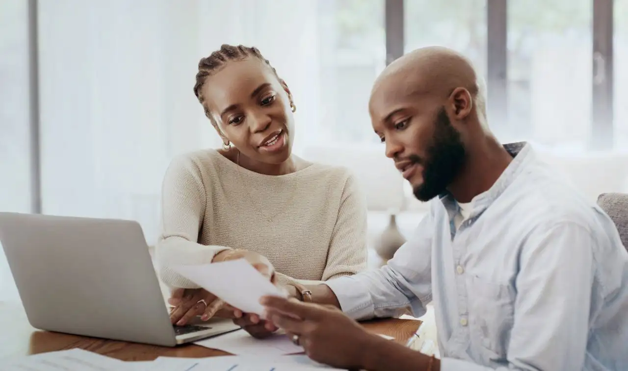 Couple using laptop and reviewing debt. Debunking debt myths