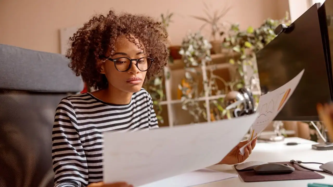 young woman adult sitting at the table and analyzing debts deciding between debt consolidation and debt resolution