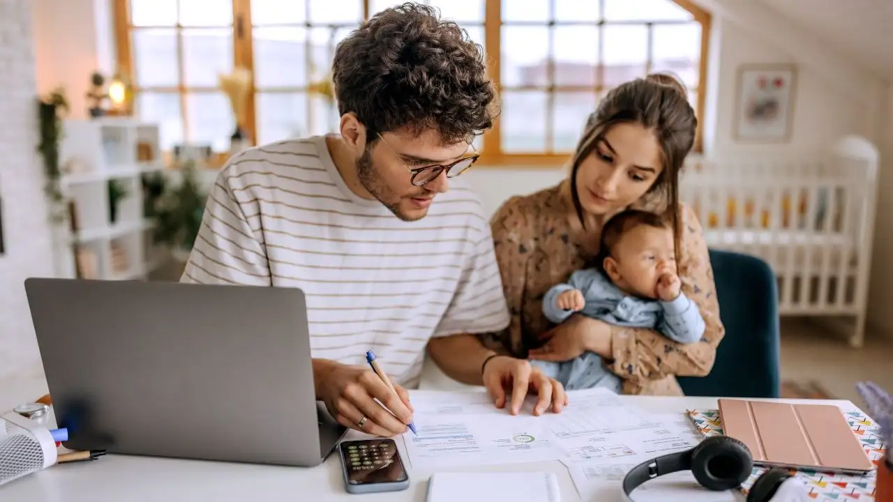 Young family with cute baby boy going over finances at home