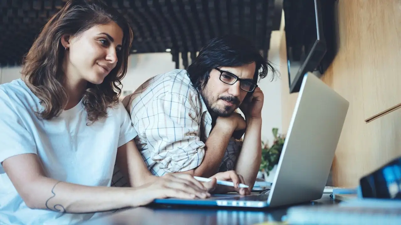 Man and woman using electronic devices, checking loan balances