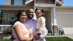 young family in front of their house.