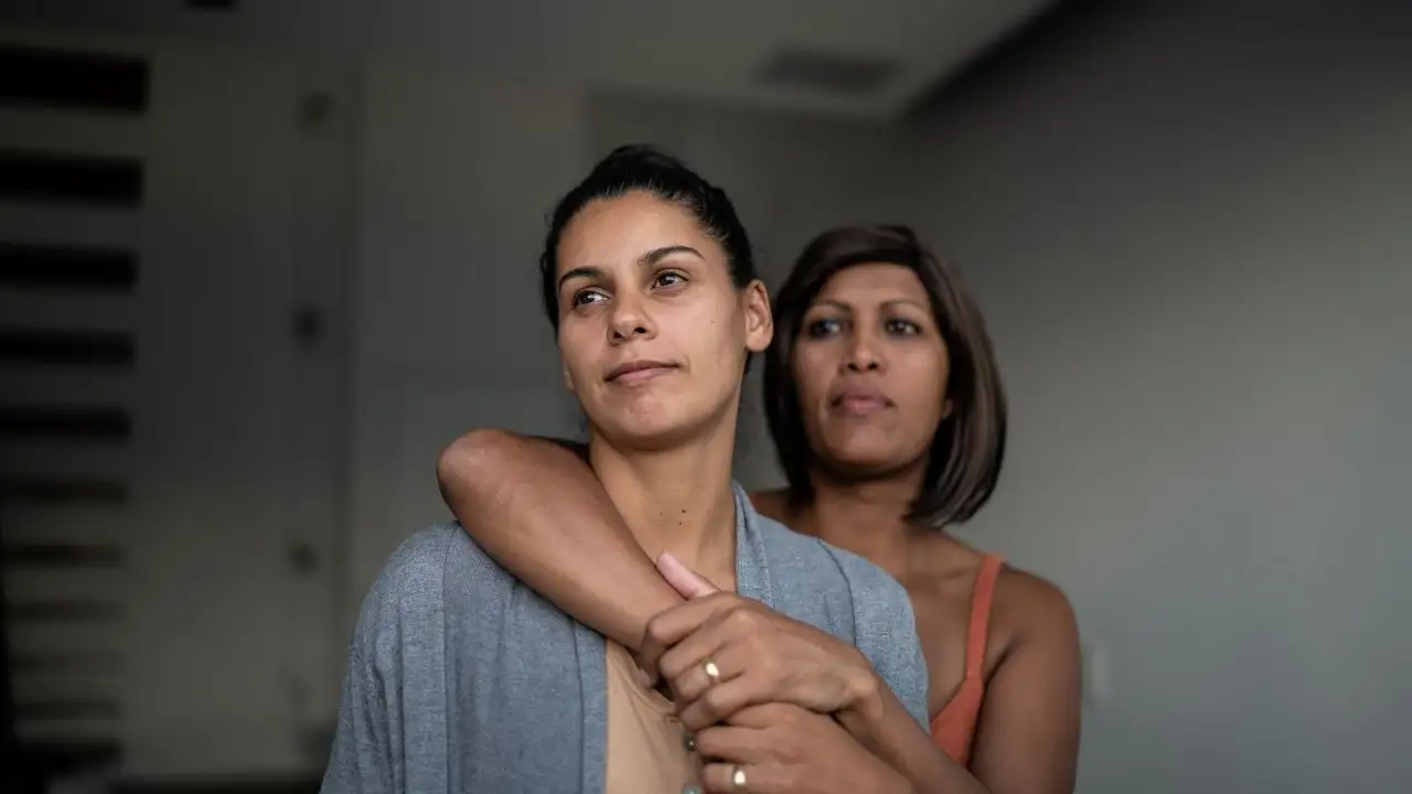 Contemplative lesbian couple at home 