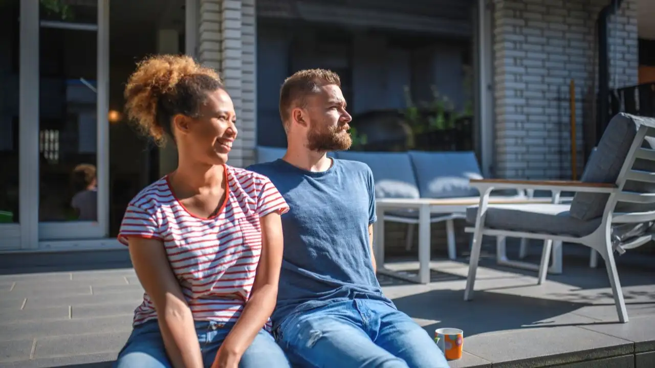 Relaxed young couple enjoying morning coffee and talking about secured debt options