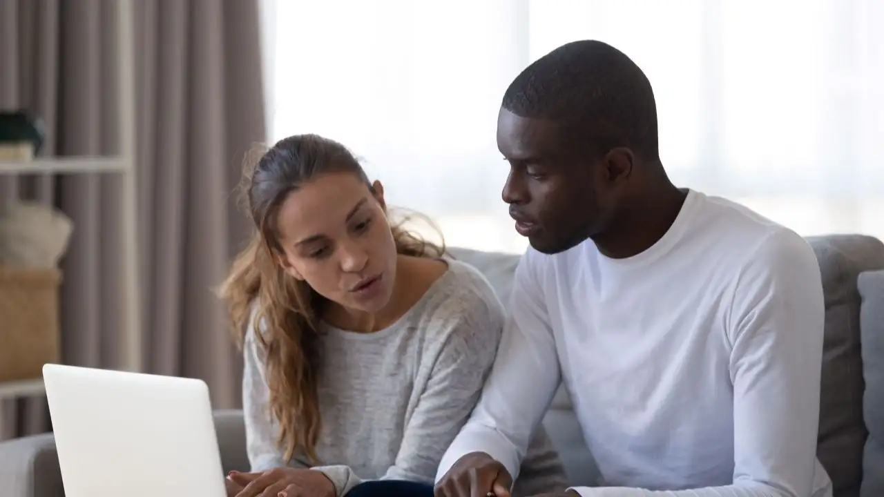 Couple reviewing bank statements online and possible overdraft limit.