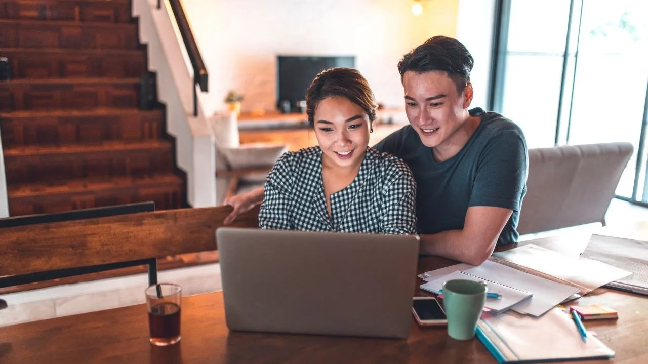 Young couple calculating monthly budget after paying off debt