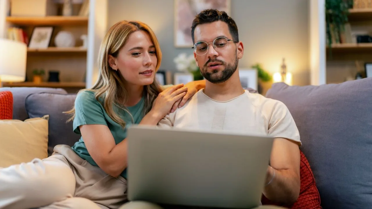 Young couple reviewing their finances while using their laptop