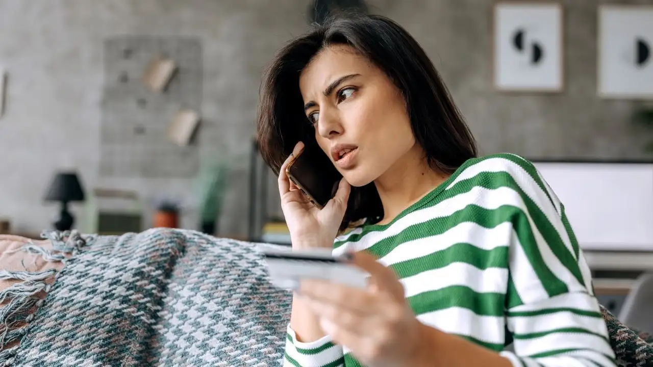 A concerned lady talking on smartphone and negotiating with a credit card company