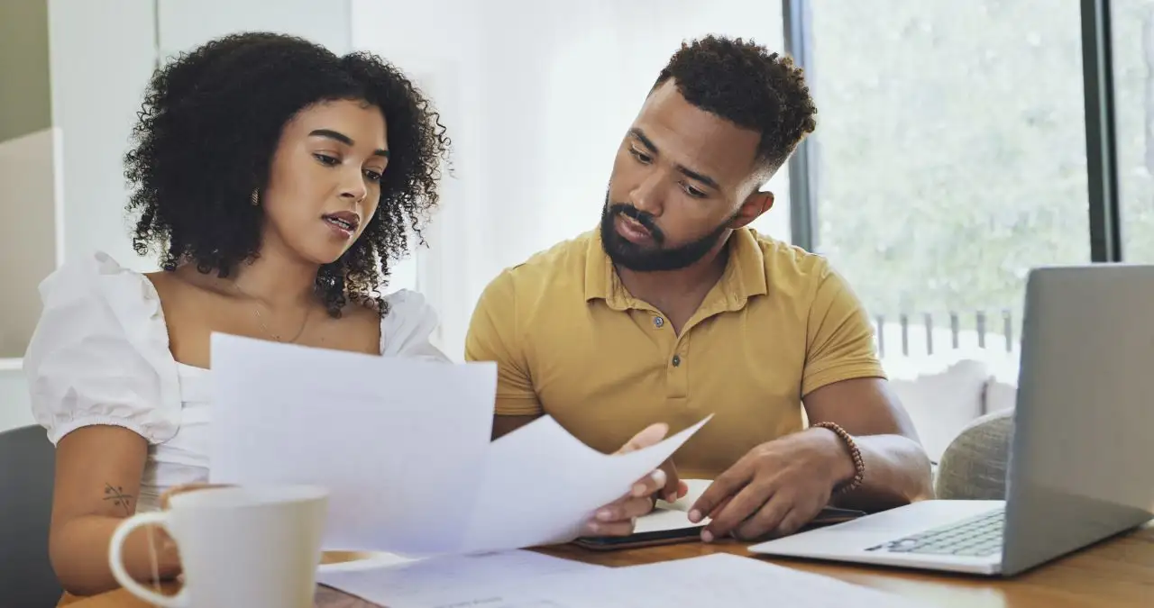 Couple reviewing credit report using a laptop at home.