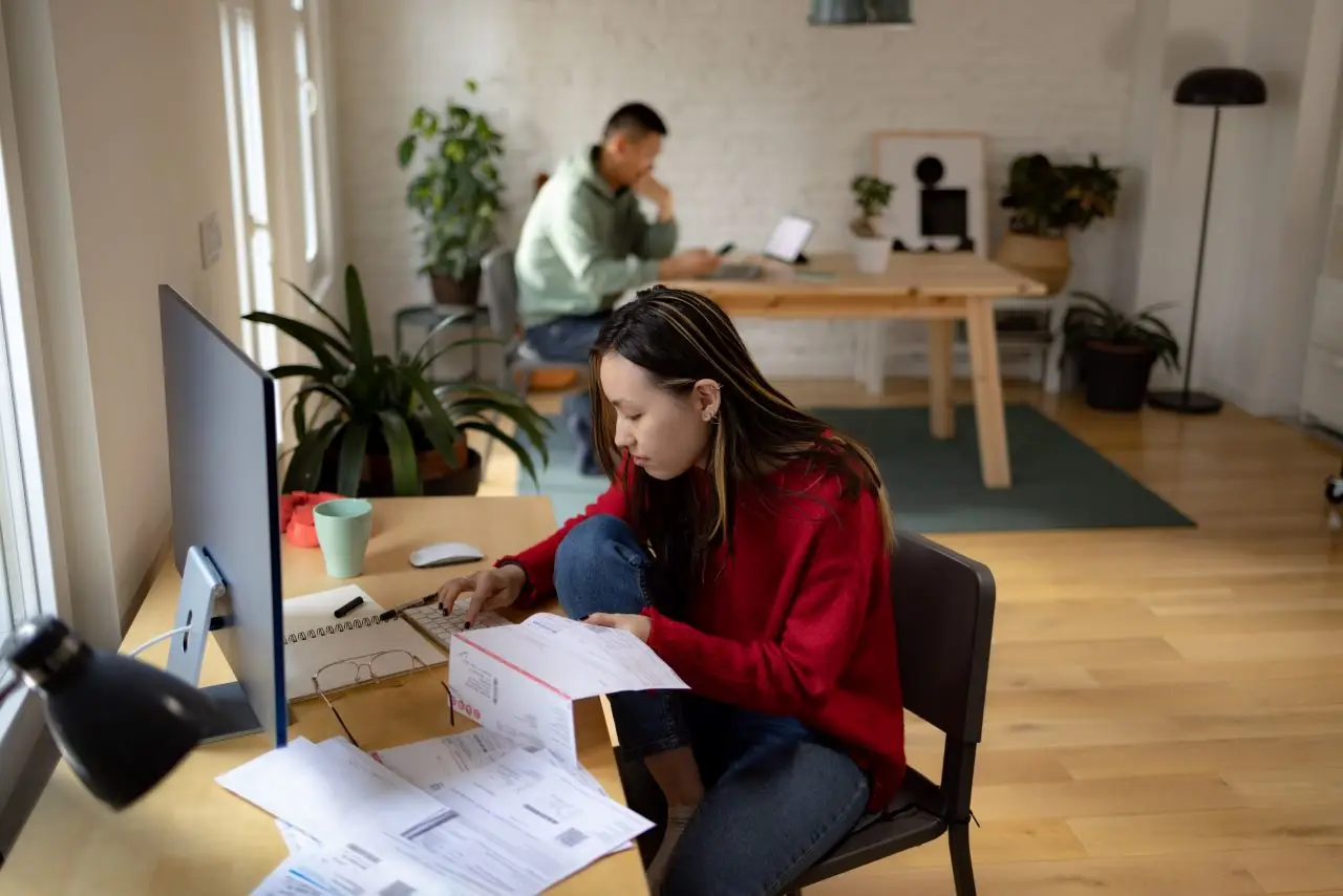 Young Asian woman paying her bills over PC at home