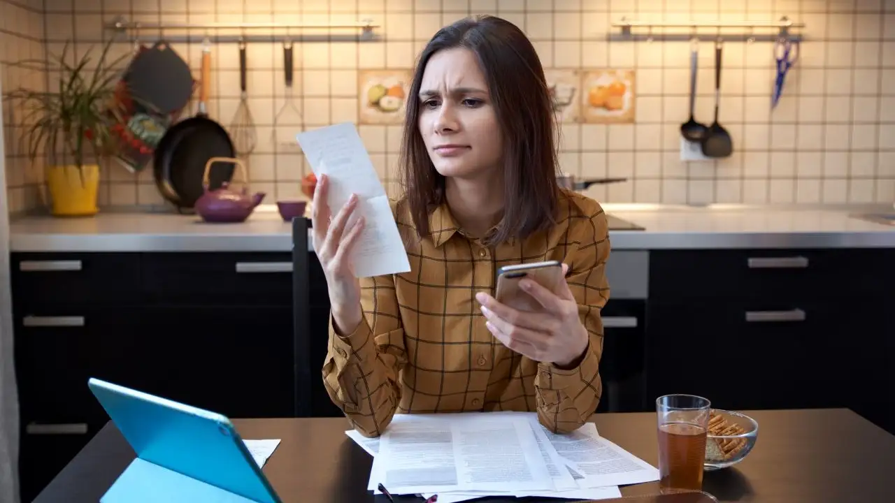 Young woman looking over bills and personal loan offer