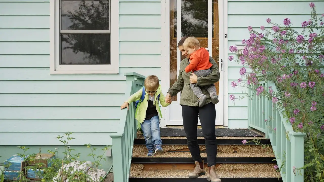 Mom and her little sons walking down the front steps of their home