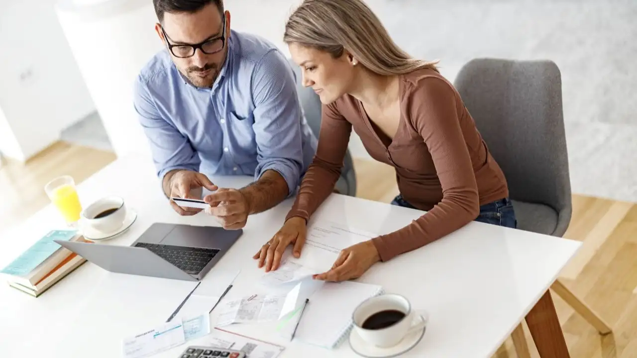 Couple paying their bills over a laptop at home